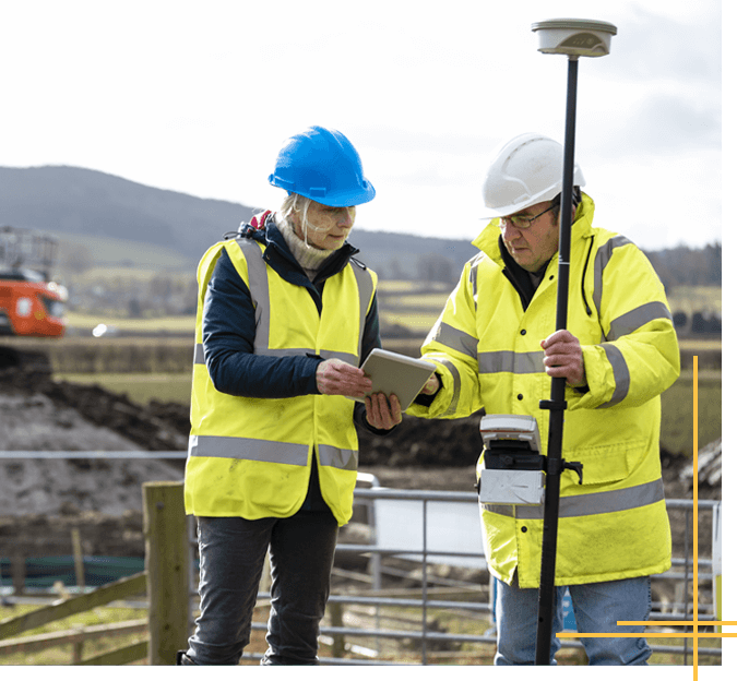 two people using surveying equipment